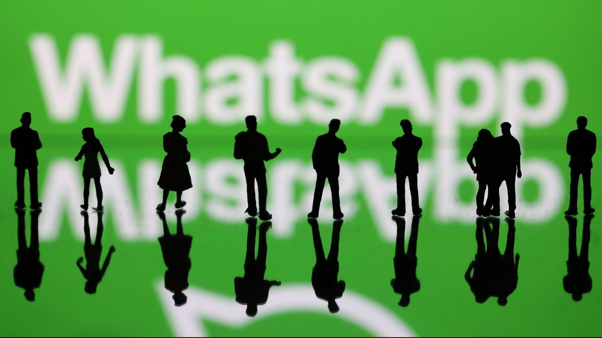 Illustration zum Messengerdienst WhatsApp: Vor dem Schriftzug "WhatsApp" stehen Menschen. Illustration zum Messengerdienst WhatsApp: Vor dem Schriftzug "WhatsApp" stehen Menschen.