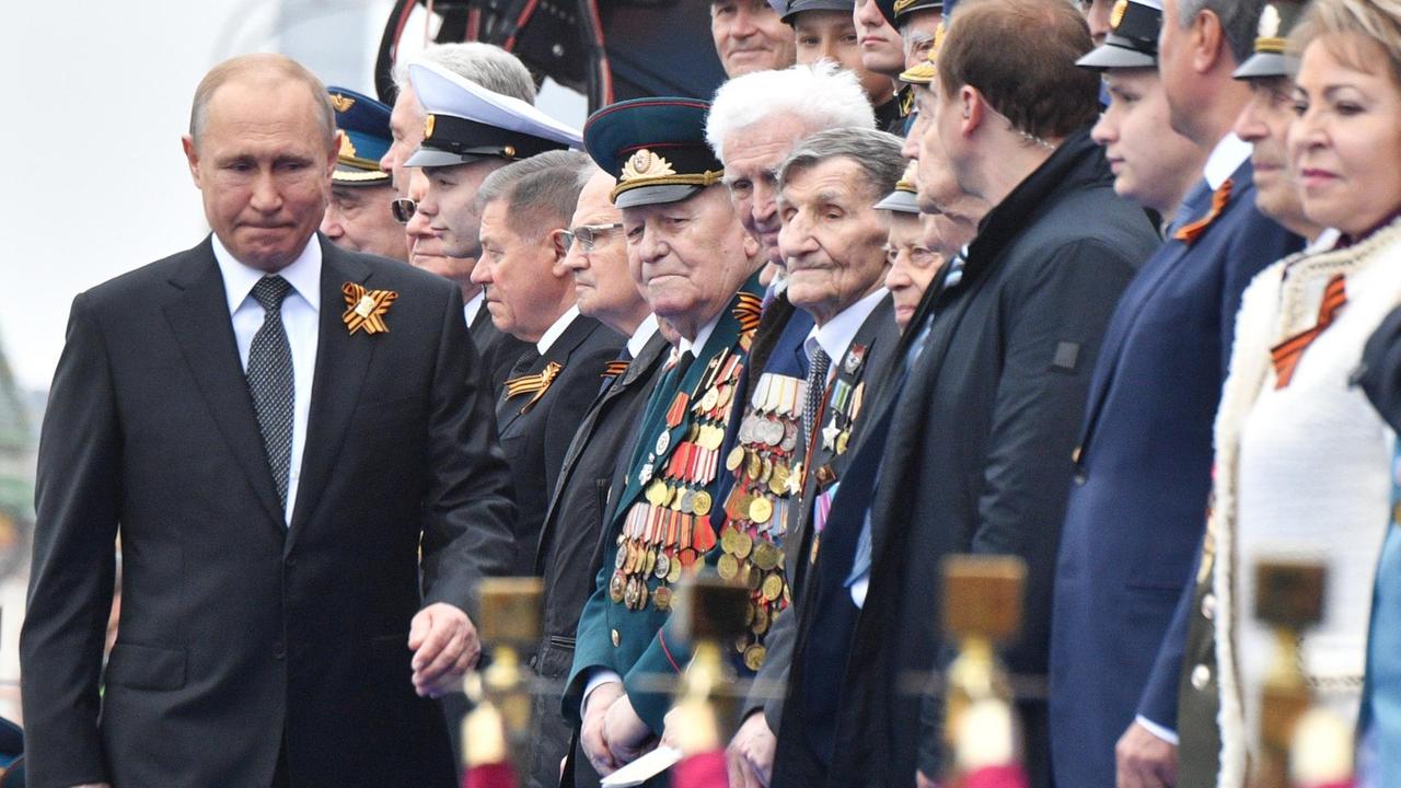 Der russische Präsident Putin geht bei der Militärparade zum Ende des Zweiten Weltkrieges an einer Reihe von Veteranen vorbei.
