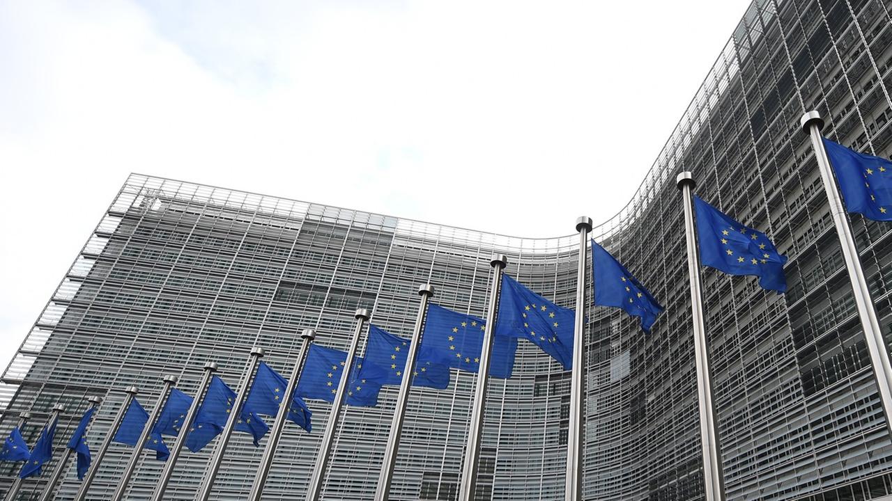 Vor dem Gebäude der EU-Kommission wehen blaue Europa-Flaggen.