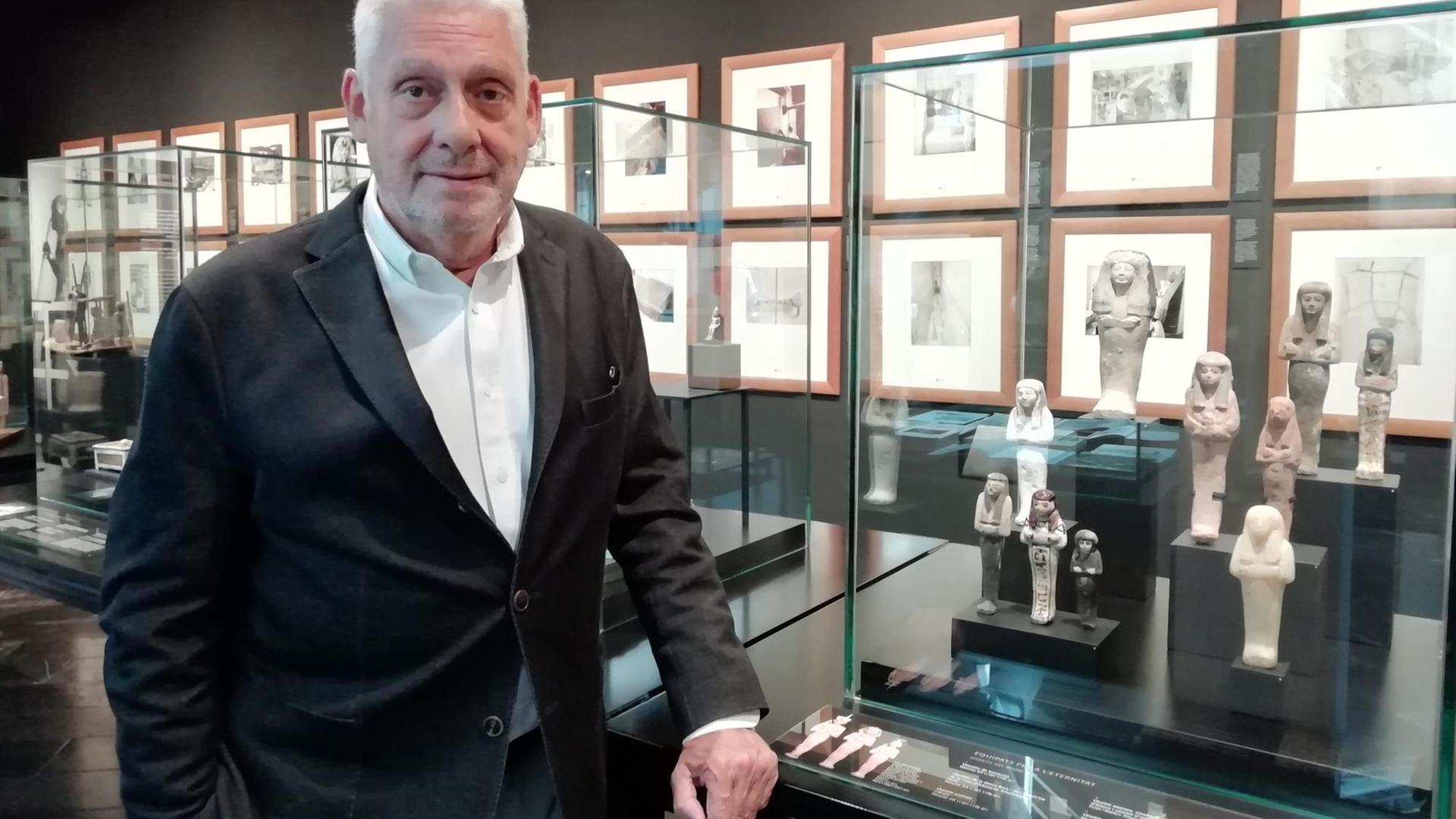 Der Sammler Jordi Clos steht vor einem Regal mit ägyptischen Figuren Der Sammler Jordi Clos steht vor einem Regal mit ägyptischen Figuren