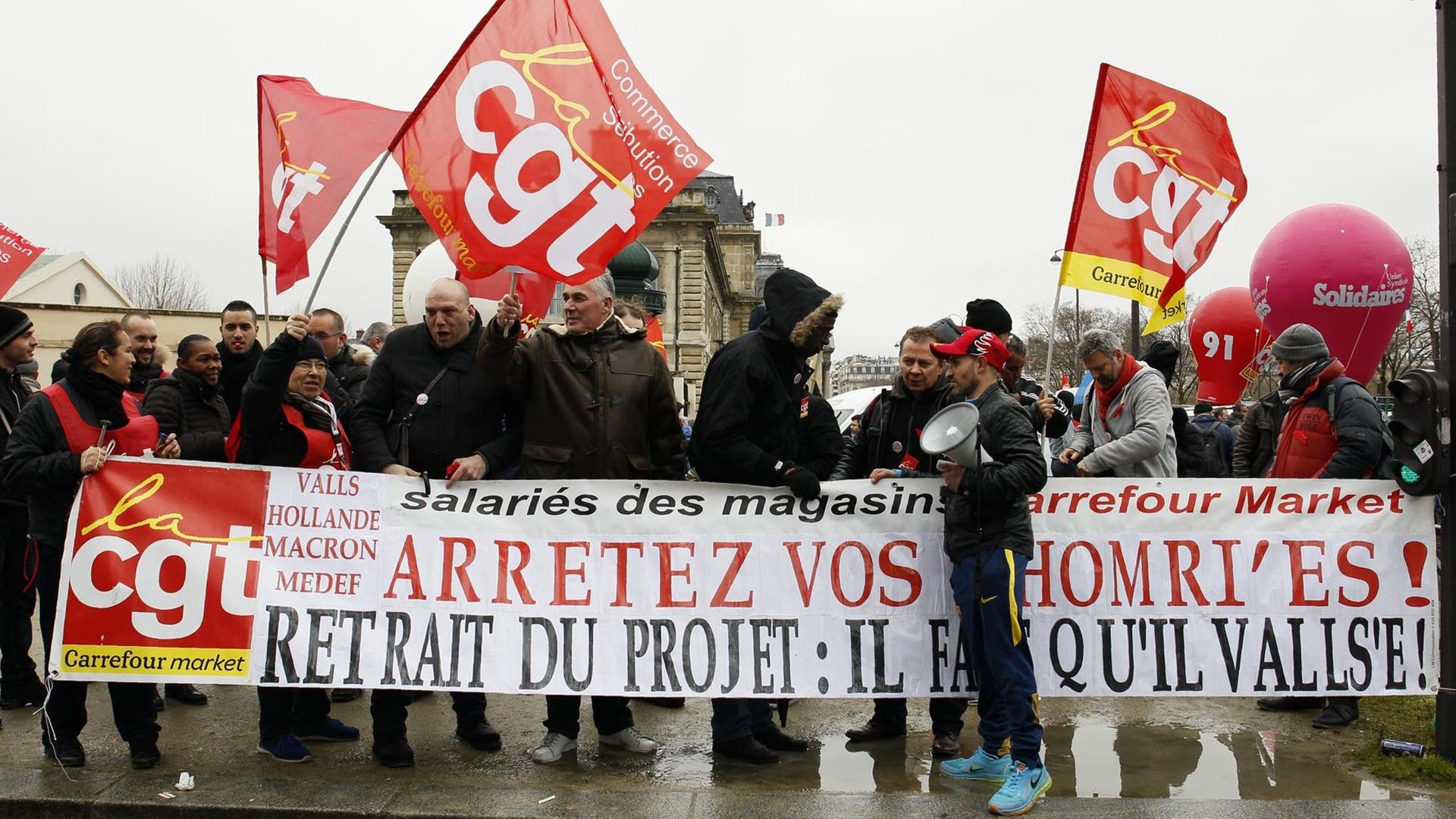 Demonstranten vor einem Supermarkt in Paris verlangen die Rücknahme der Reformpläne der Regierung. Demonstranten vor einem Supermarkt in Paris verlangen die Rücknahme der Reformpläne der Regierung.