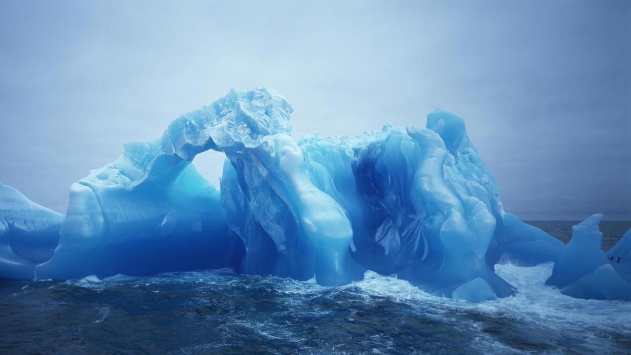 Ein blauer Eisberg schwimmt in der Antarktis