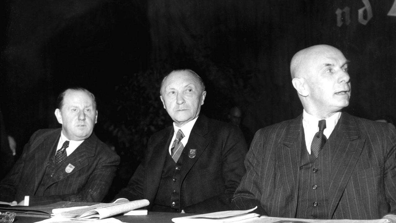 Friedrich Holzapfel (l-r), Konrad Adenauer und Jakob Kaiser sitzen auf dem Gründungsparteitag der CDU in Goslar. Friedrich Holzapfel (l-r), Konrad Adenauer und Jakob Kaiser sitzen auf dem Gründungsparteitag der CDU in Goslar.
