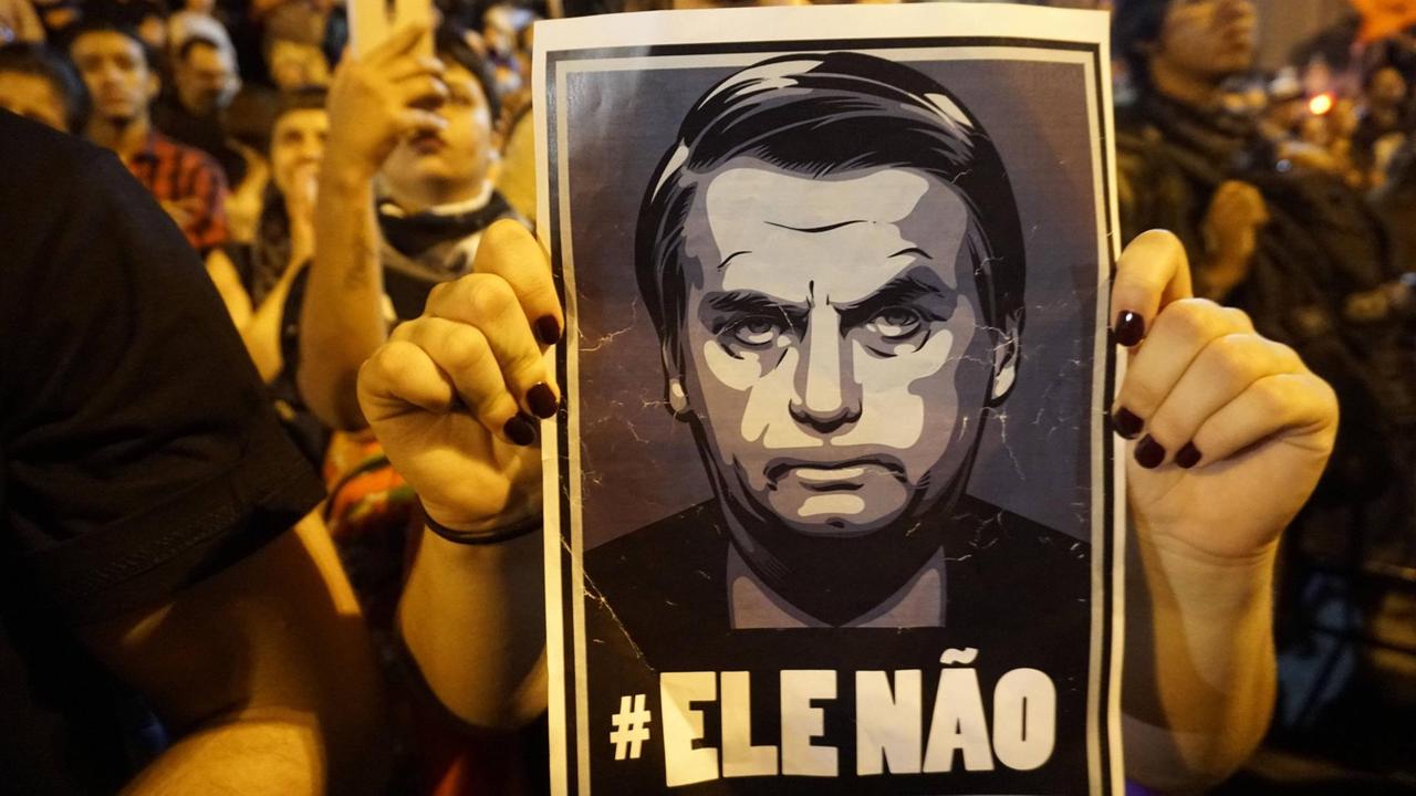 Auf einem Protestplakat ist ein Bild von Jair Bolsonaro zu sehen. Auf einem Protestplakat ist ein Bild von Jair Bolsonaro zu sehen.