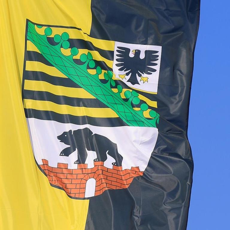 Eine Flagge des Landes Sachsen-Anhalt weht in Marienborn (Sachsen-Anhalt) vor einem blauen Himmel. 