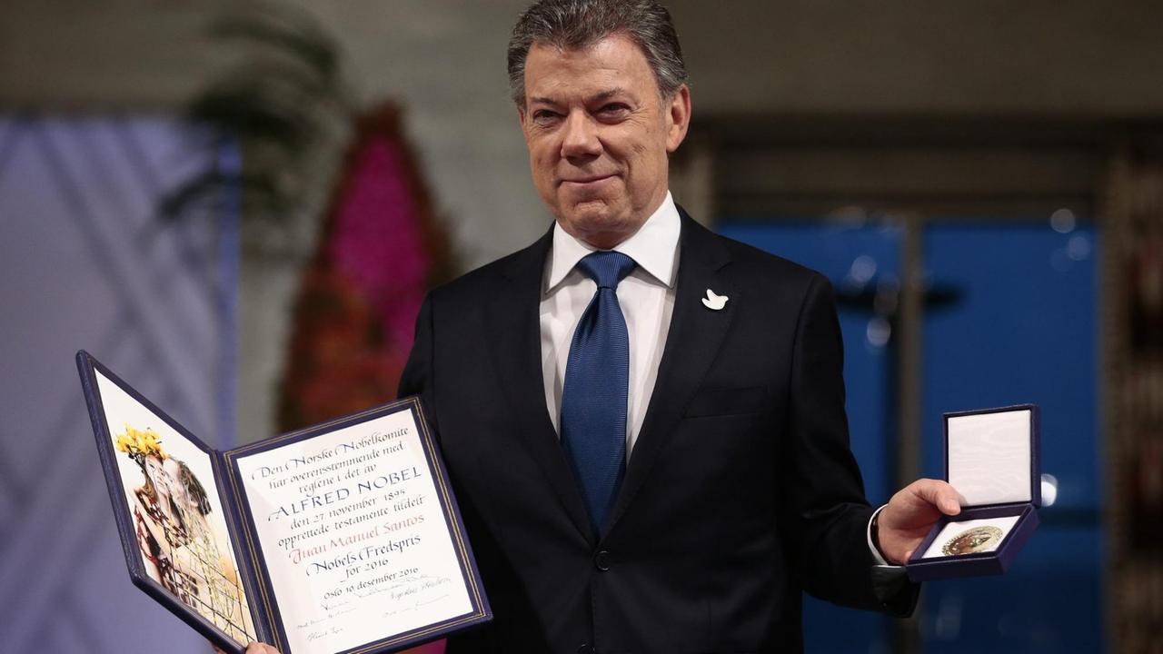 Der kolumbianische Präsident Santos zeigt in Oslo die Urkunde und die Medaille des Friedensnobelpreises 2016 Der kolumbianische Präsident Santos zeigt in Oslo die Urkunde und die Medaille des Friedensnobelpreises 2016