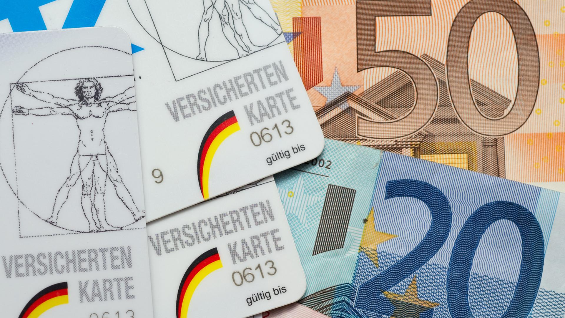 Krankenkassen-Karten liegen neben Euro-Scheinen. Krankenkassen-Karten liegen neben Euro-Scheinen.