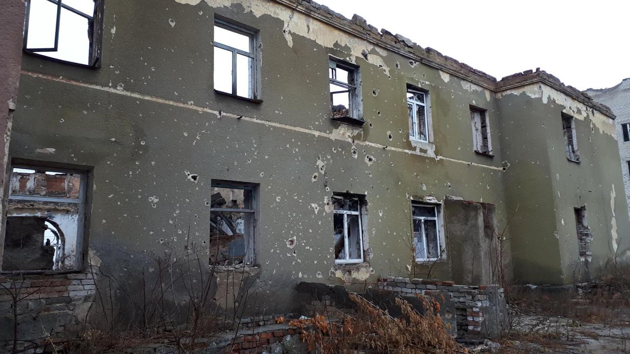 Seitenteil eines grünen, zerschossenen Gebäudes Seitenteil eines grünen, zerschossenen Gebäudes