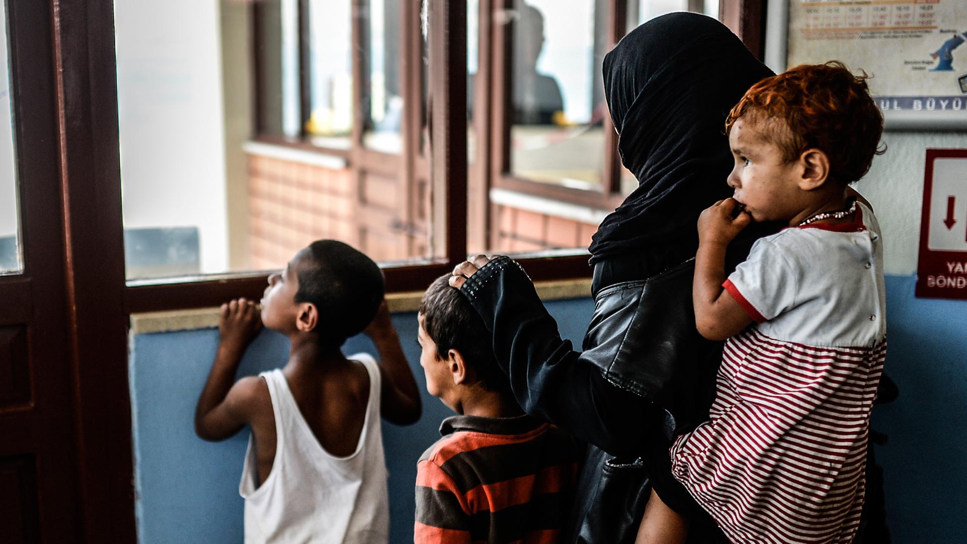 Eine Syrerin wartet in Istanbul mit Kindern auf eine Fähre Eine Syrerin wartet in Istanbul mit Kindern auf eine Fähre