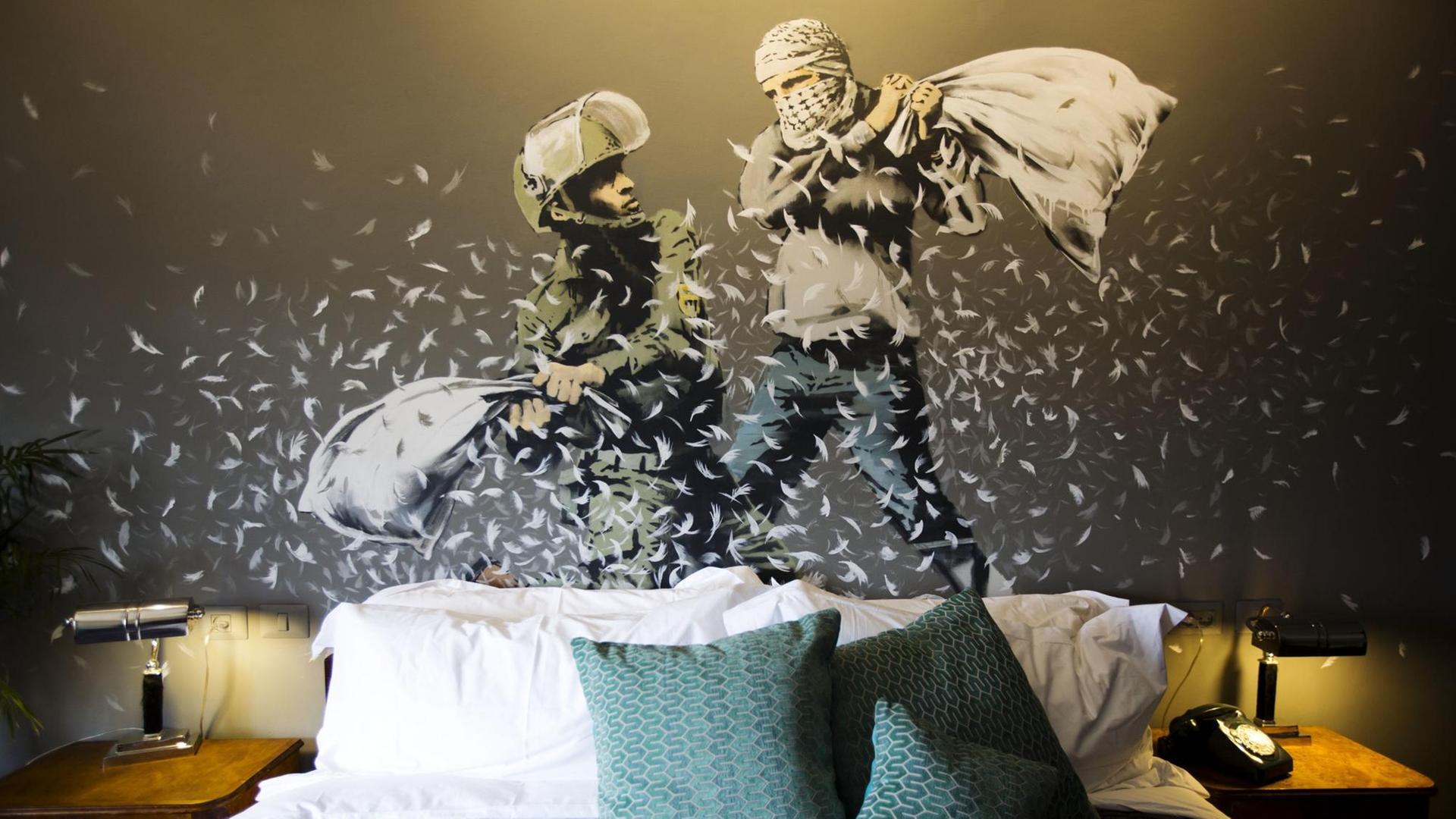 Ein Wandbild des britischen Street-Art Künstlers Banksy ist in Bethlehem (Westjordanland) in einem Raum des "The Walled Off Hotel" zu sehen. Ein Wandbild des britischen Street-Art Künstlers Banksy ist in Bethlehem (Westjordanland) in einem Raum des "The Walled Off Hotel" zu sehen.