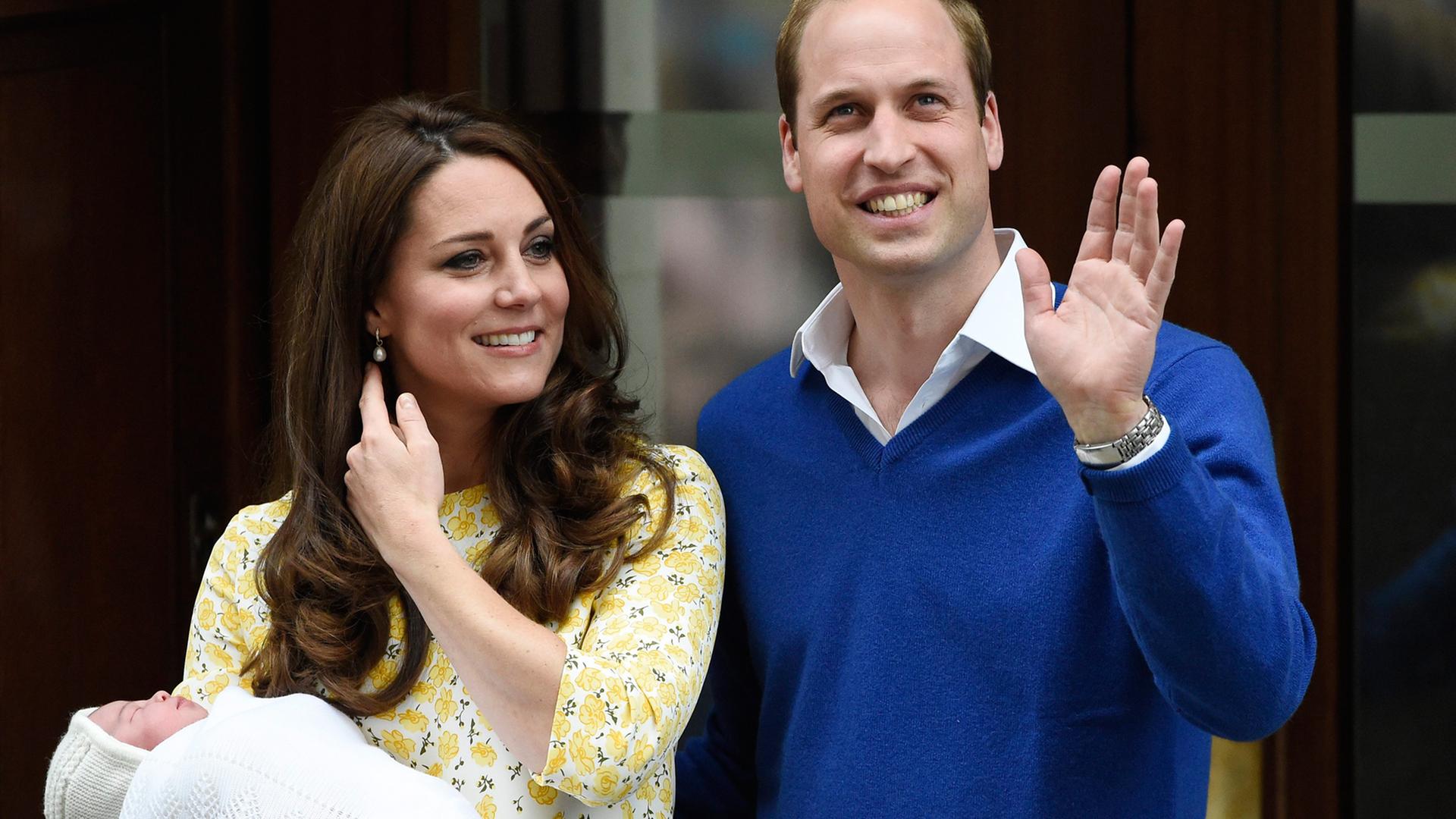 Kate hält das Baby in ihrem Arm, neben ihr William, der winkt. Kate hält das Baby in ihrem Arm, neben ihr William, der winkt.