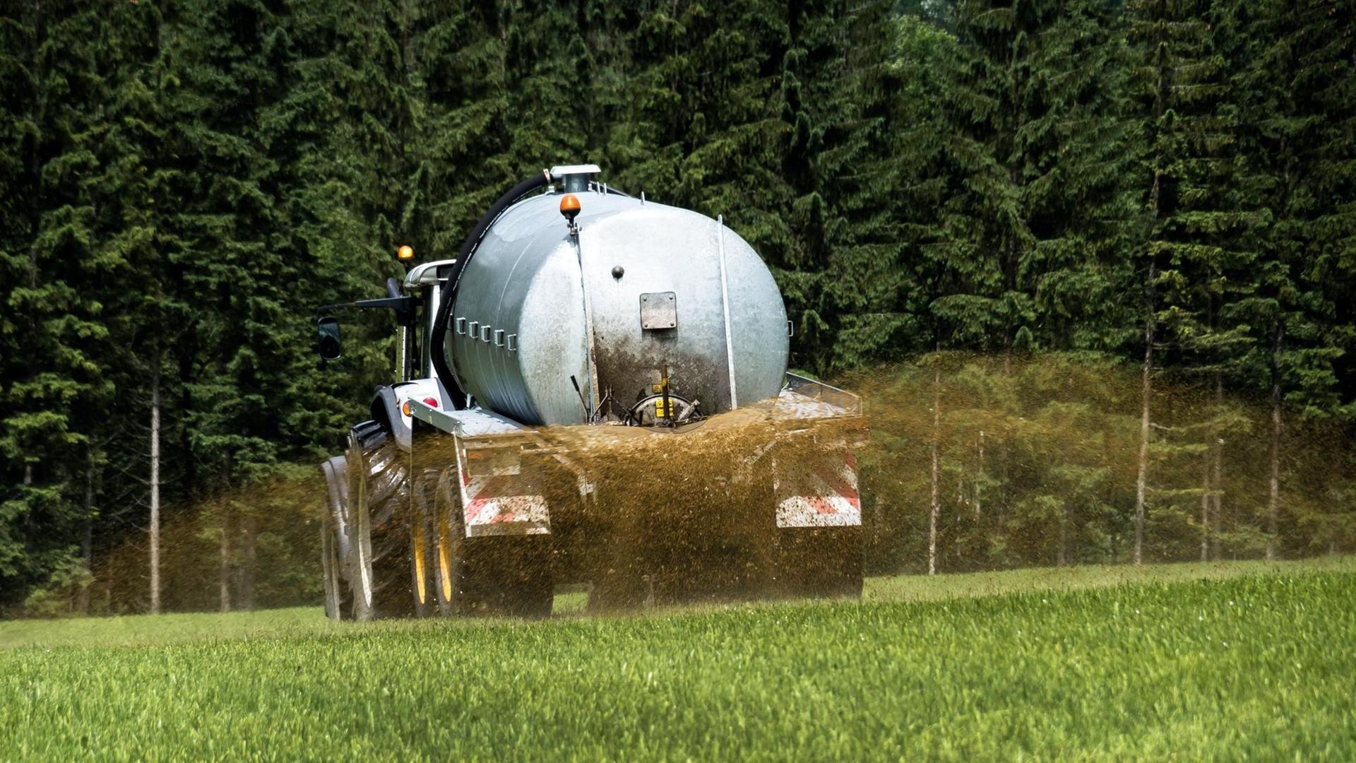 Ein Bauer bringt mit einem Traktor Gülle auf ein Feld. Ein Bauer bringt mit einem Traktor Gülle auf ein Feld.
