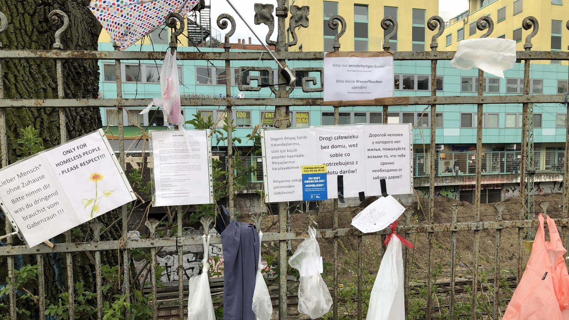 Ein Zaun mitten in der Stadt, an dem Spenden für Obdachlose aufgehängt werden können
