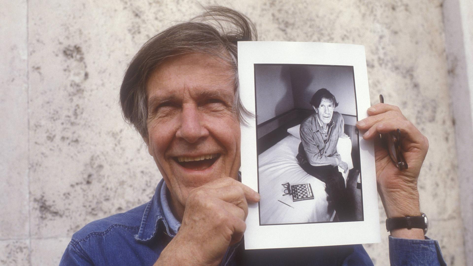 Der US-amerikanische Komponist John Cage (1912 – 1992) zeigt ein Foto von sich aus den frühen 80er-Jahren Der US-amerikanische Komponist John Cage (1912 – 1992) zeigt ein Foto von sich aus den frühen 80er-Jahren