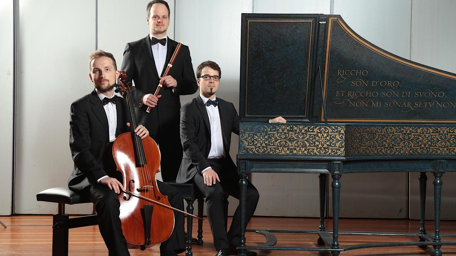 Das Ensemble Cicerone mit Thomas Wormitt - Traversflöte, Adrian Cygan - Violoncello und Andreas Gilger - Cembalo Die Musik tragen Konzertkleidung und posieren mit ihren histroischen Instrumenten in einem gestellten Foto Das Ensemble Cicerone mit Thomas Wormitt - Traversflöte, Adrian Cygan - Violoncello und Andreas Gilger - Cembalo Die Musik tragen Konzertkleidung und posieren mit ihren histroischen Instrumenten in einem gestellten Foto