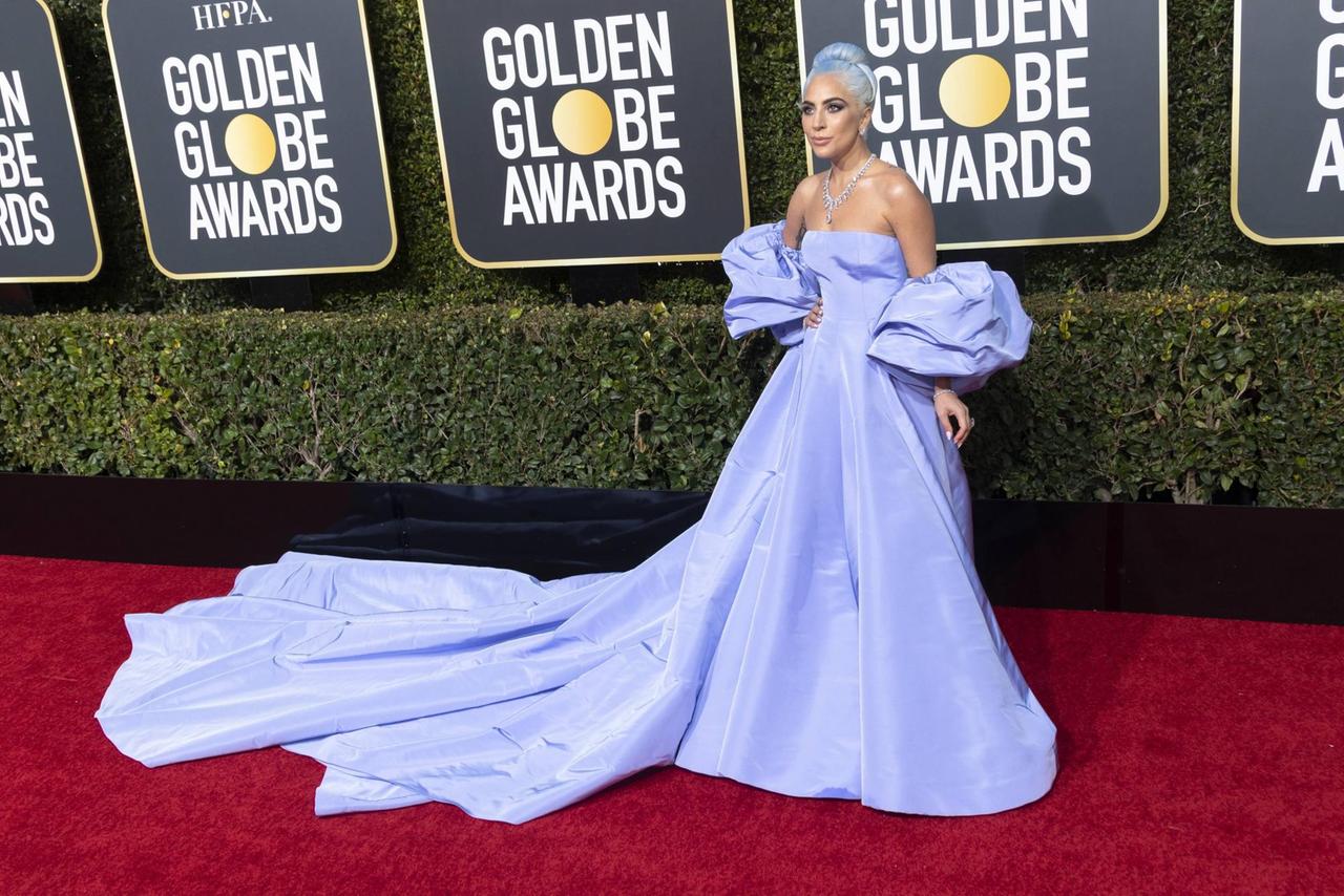 Lady Gaga bei der 76. Verleihung der Golden Globe Awards in Beverly Hills posiert in einem hell-blauen, langen Kleid, das sich über den roten Teppich zieht 