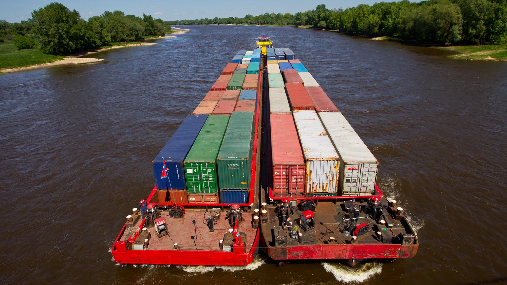 Container werden mit einem Schubverband auf der Elbe in Magdeburg transportiert. Container werden mit einem Schubverband auf der Elbe in Magdeburg transportiert.