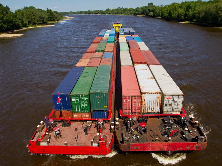 Container werden mit einem Schubverband auf der Elbe in Magdeburg transportiert.