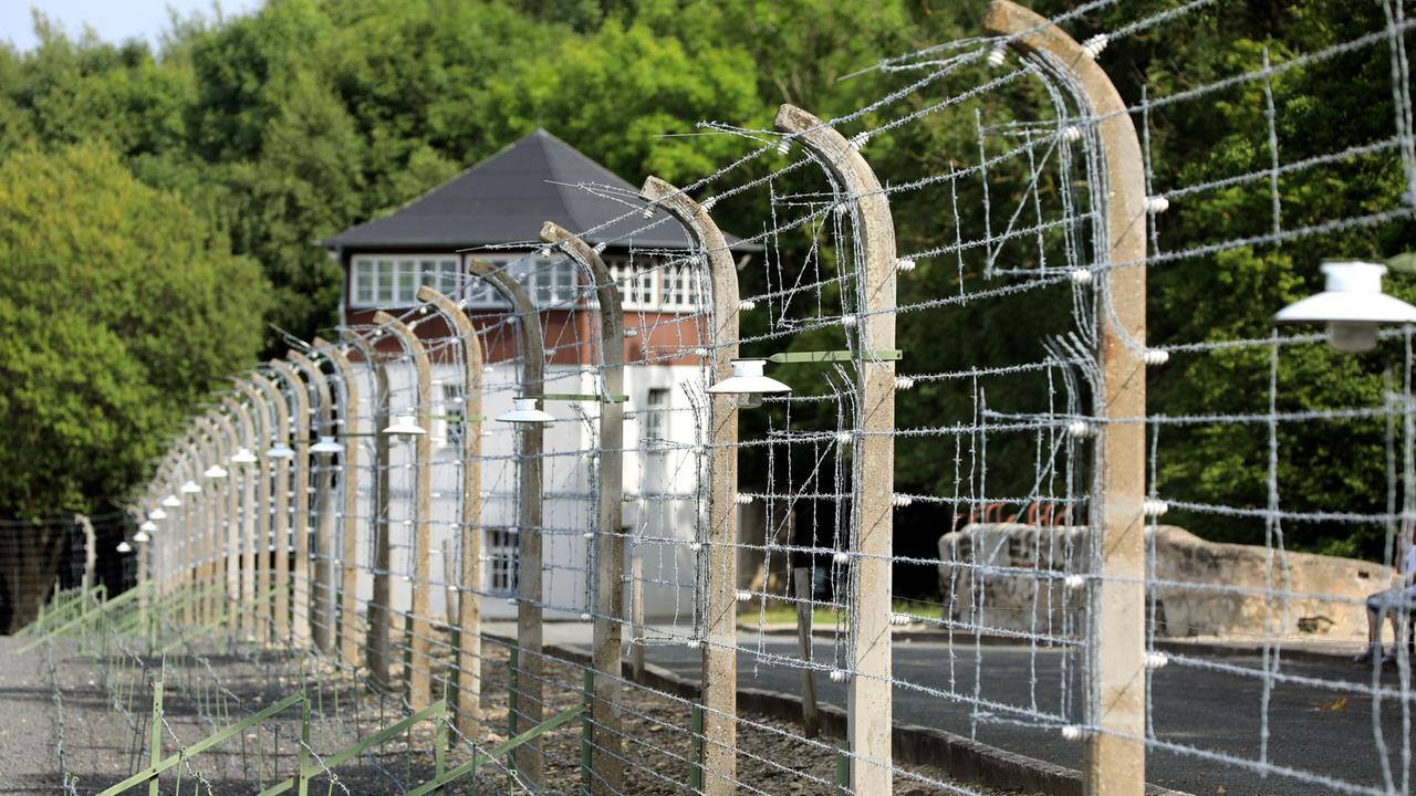 Gedenkstätte KZ Buchenwald: Blick durch den Stacheldrahtzaun auf das ehemalige Häftlingslager des früheren KZ Buchenwald, aufgenommen am 30.08.2017 bei Weimar (Thüringen) Gedenkstätte KZ Buchenwald: Blick durch den Stacheldrahtzaun auf das ehemalige Häftlingslager des früheren KZ Buchenwald, aufgenommen am 30.08.2017 bei Weimar (Thüringen)
