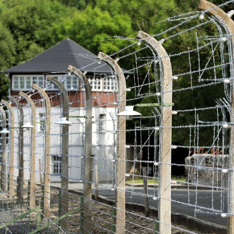 Gedenkstätte KZ Buchenwald: Blick durch den Stacheldrahtzaun auf das ehemalige Häftlingslager des früheren KZ Buchenwald, aufgenommen am 30.08.2017 bei Weimar (Thüringen)