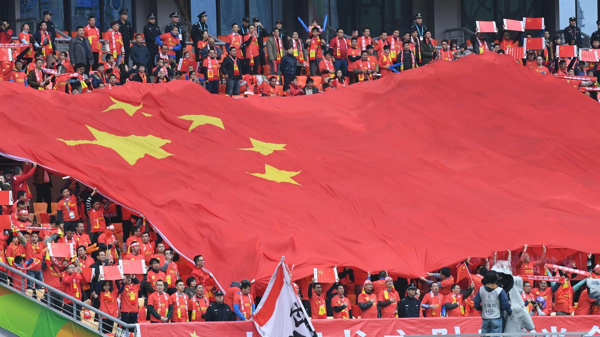 Chinesiche Fußballfans schwenken ein Fahne beim Gree China Cup International Football Championschip in Nanning, China. Chinesiche Fußballfans schwenken ein Fahne beim Gree China Cup International Football Championschip in Nanning, China.