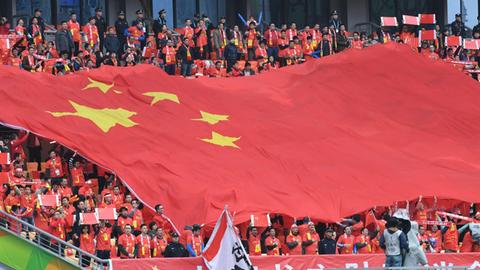 Chinesiche Fußballfans schwenken ein Fahne beim Gree China Cup International Football Championschip in Nanning, China.