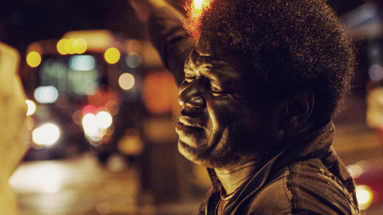 Charles Bradley mit geschlossenen Augen in einer nächtlich-urban erleuchteten, unscharfen Umgebung. Charles Bradley mit geschlossenen Augen in einer nächtlich-urban erleuchteten, unscharfen Umgebung.