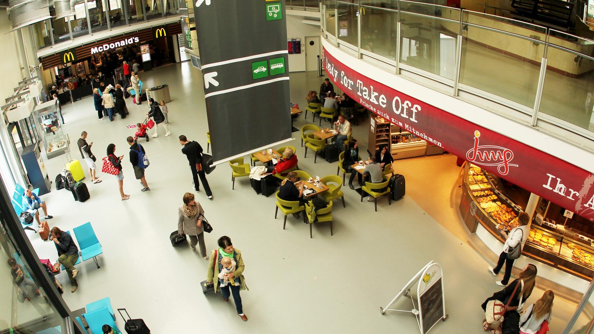 Passagiere laufen durch das Passagierterminal des Flughafens Frankfurt/Hahn in Lautzenhausen (Rheinland-Pfalz). Passagiere laufen durch das Passagierterminal des Flughafens Frankfurt/Hahn in Lautzenhausen (Rheinland-Pfalz).