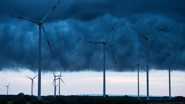 Windenergieanlagen sind am 04.09.2016 unter dunklen Gewitterwolken über dem Landkreis Oder-Spree nahe Sieversdorf (Brandenburg) zu sehen.