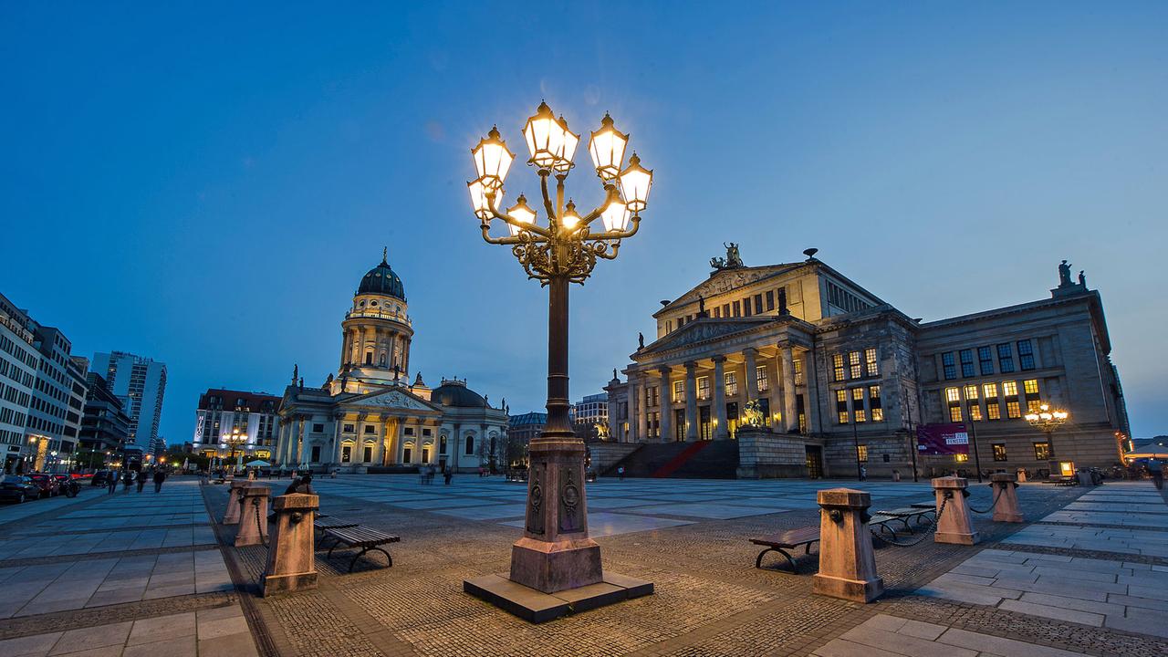 Eine historische Straßenlaterne leuchtet in Berlin am Gendarmenmarkt. Der Platz in Mitte ist ein Anziehungspunkt für Touristen. Sie begeistern sich für das Konzerthaus (rechts) oder den Deutschen Dom. Eine historische Straßenlaterne leuchtet in Berlin am Gendarmenmarkt. Der Platz in Mitte ist ein Anziehungspunkt für Touristen. Sie begeistern sich für das Konzerthaus (rechts) oder den Deutschen Dom.