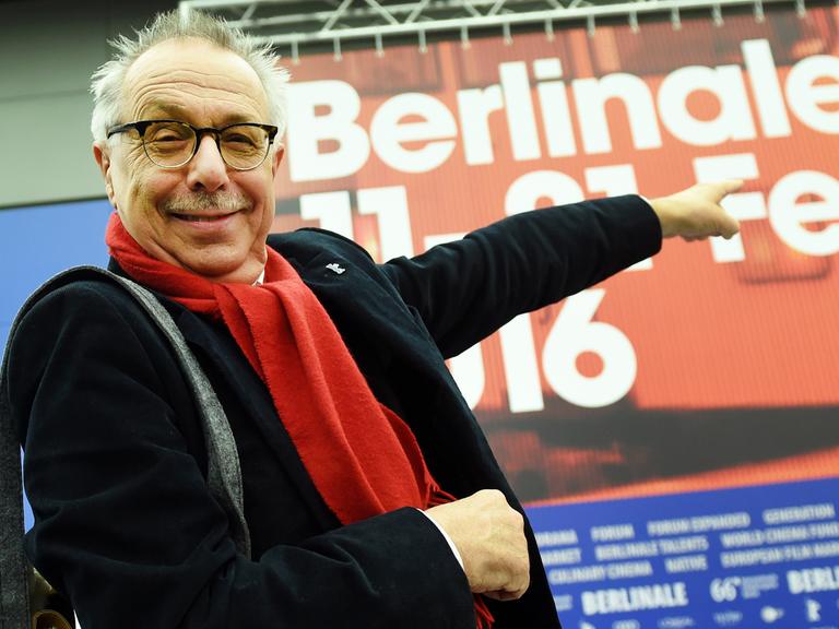 Kosslick zeigt auf ein rotes Film-Plakat der Berlinale