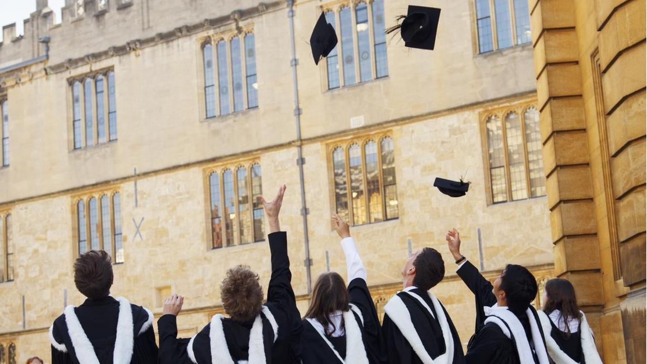 Bachelors der University of Oxford in Grossbritannien werfen ihre Hüte in die Luft vor dem Universitätsgebäude. Bachelors der University of Oxford in Grossbritannien werfen ihre Hüte in die Luft vor dem Universitätsgebäude.