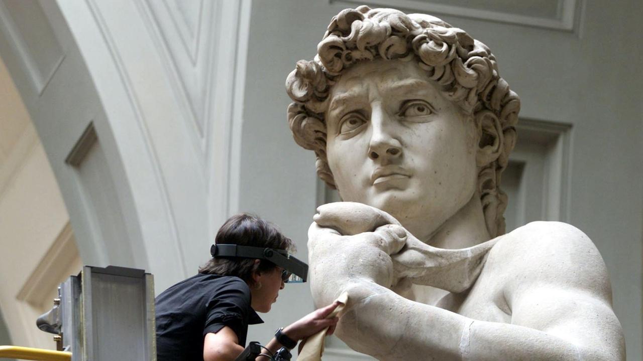Ein Restaurator arbeitet an der Hand der David-Statue von Michelangelo in der Akademie in Florenz. Ein Restaurator arbeitet an der Hand der David-Statue von Michelangelo in der Akademie in Florenz.