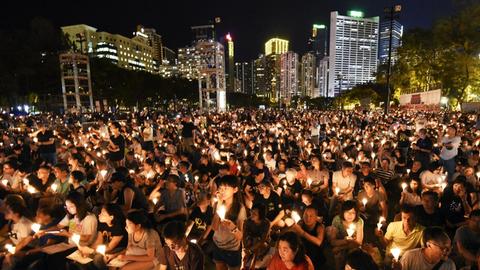 Vor der Hochhauskulisse Hongkongs stehen zehntausende Menschen mit Kerzen in den Händen, um des Tiananmen-Massakers von 1989 zu gedenken.