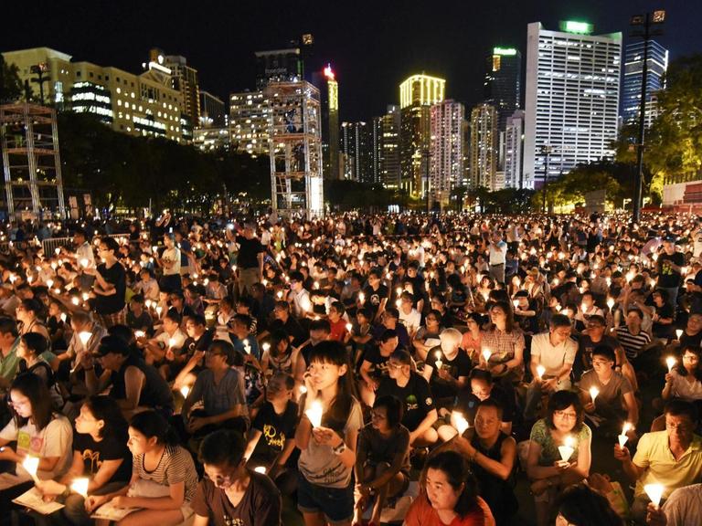 Vor der Hochhauskulisse Hongkongs stehen zehntausende Menschen mit Kerzen in den Händen, um des Tiananmen-Massakers von 1989 zu gedenken.