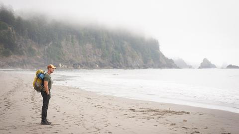 Ein Wanderer steht am Toleak Point (USA) und blickt auf das Meer.