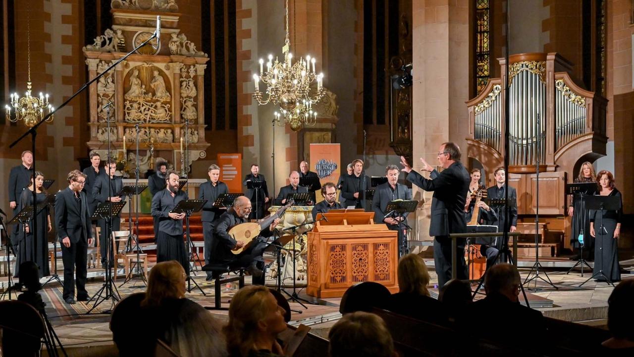 Musiker und Sänger stehen locker verteilt im Kirchenraum vor einem Publikum - und halten Corona-konform Abstand. Musiker und Sänger stehen locker verteilt im Kirchenraum vor einem Publikum - und halten Corona-konform Abstand.
