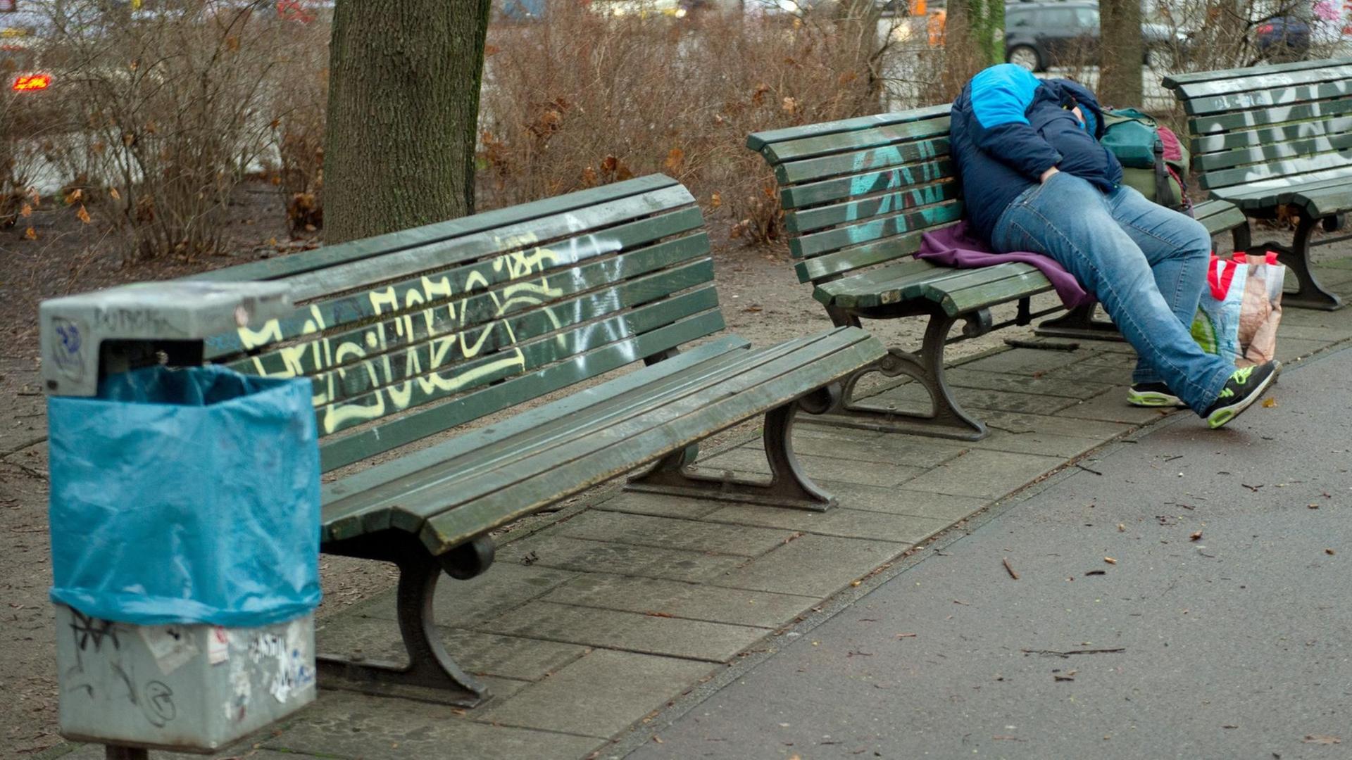 Ein Obdachloser schläft in Berlin auf einer Parkbank Ein Obdachloser schläft in Berlin auf einer Parkbank