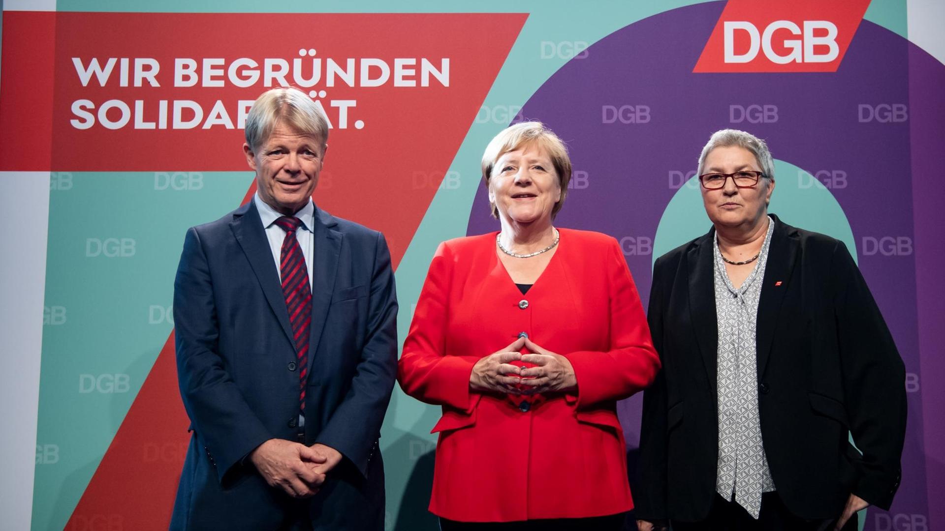 Bundeskanzlerin Angela Merkel (M, CDU) wird von Reiner Hoffmann (l), DGB-Vorsitzender, und Elke Hannack, stellvertretende DGB-Vorsitzende, beim Festakt zu 70 Jahre Deutscher Gewerkschaftsbund (DGB) begrüßt.