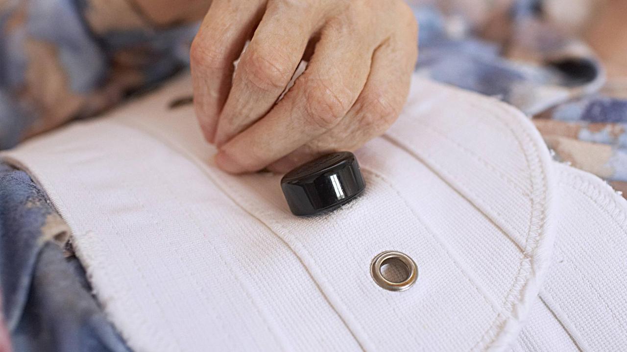 Eine alte Frau ist mit einem Bauchgurt an ihrem Bett fixiert um sie am Aussteigen zu hindern Eine alte Frau ist mit einem Bauchgurt an ihrem Bett fixiert um sie am Aussteigen zu hindern