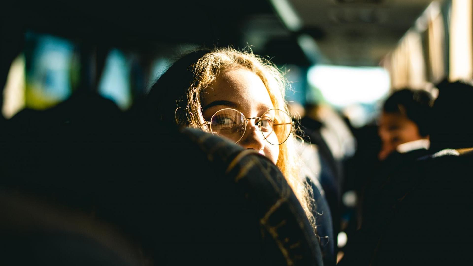 Eine Frau im Bus dreht sich von ihrem Sitz um und schaut in die Kamera. Eine Frau im Bus dreht sich von ihrem Sitz um und schaut in die Kamera.
