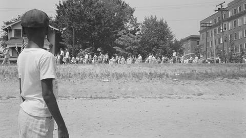 August 1959. Junger schwarzer Amerikaner schaut bei einem Protestmarsch zu