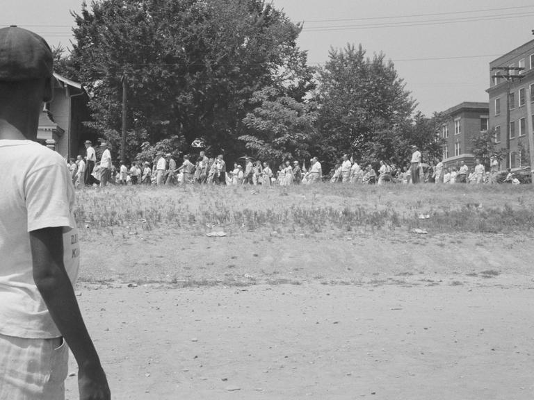 August 1959. Junger schwarzer Amerikaner schaut bei einem Protestmarsch zu