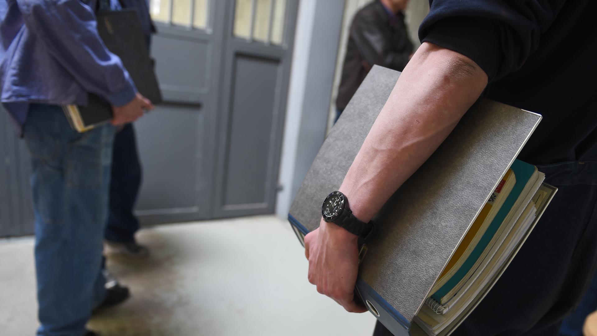 Häftlinge in einer Justizvollzugsanstalt vor einer geschlossenen Eingangstür zum Schultrakt. Häftlinge in einer Justizvollzugsanstalt vor einer geschlossenen Eingangstür zum Schultrakt.