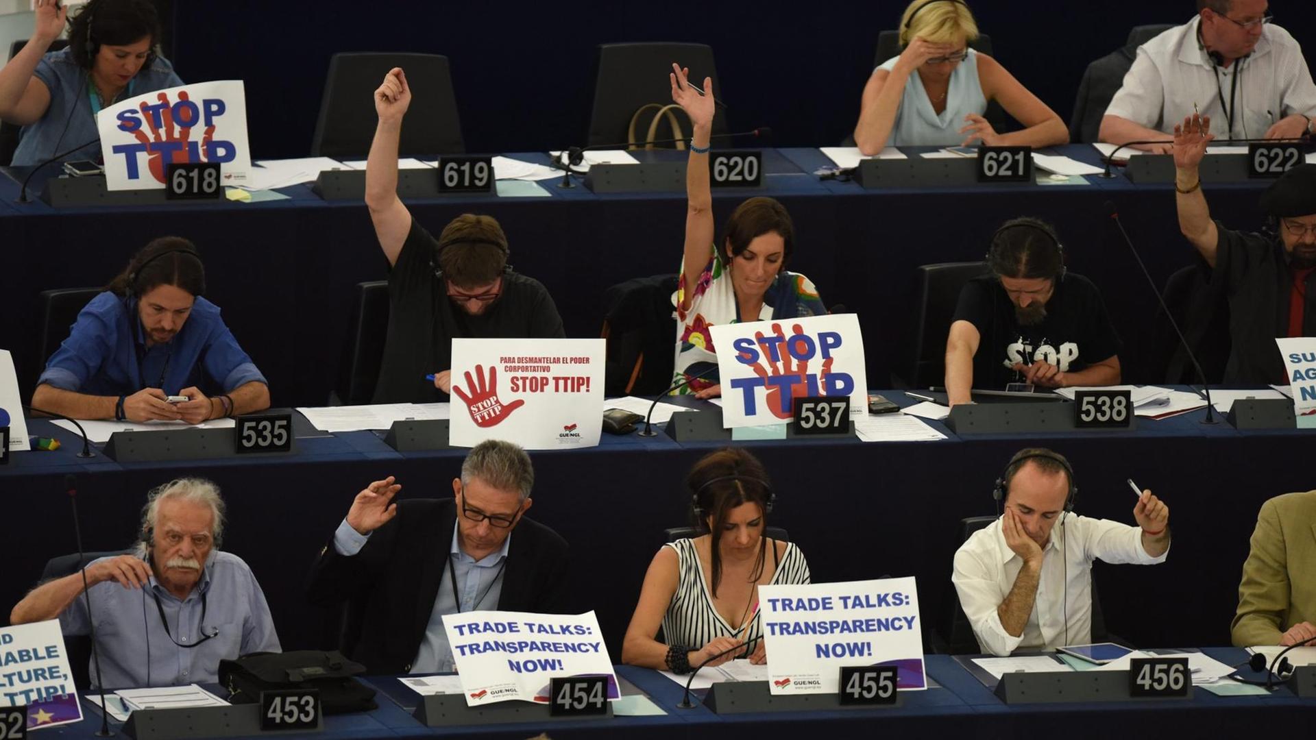Vertreter der "Konföderalen Fraktion der Vereinten Europäischen Linken/Nordischen Grünen Linken" protestieren im Europa-Parlament gegen das Freihandelsabkommen TTIP.