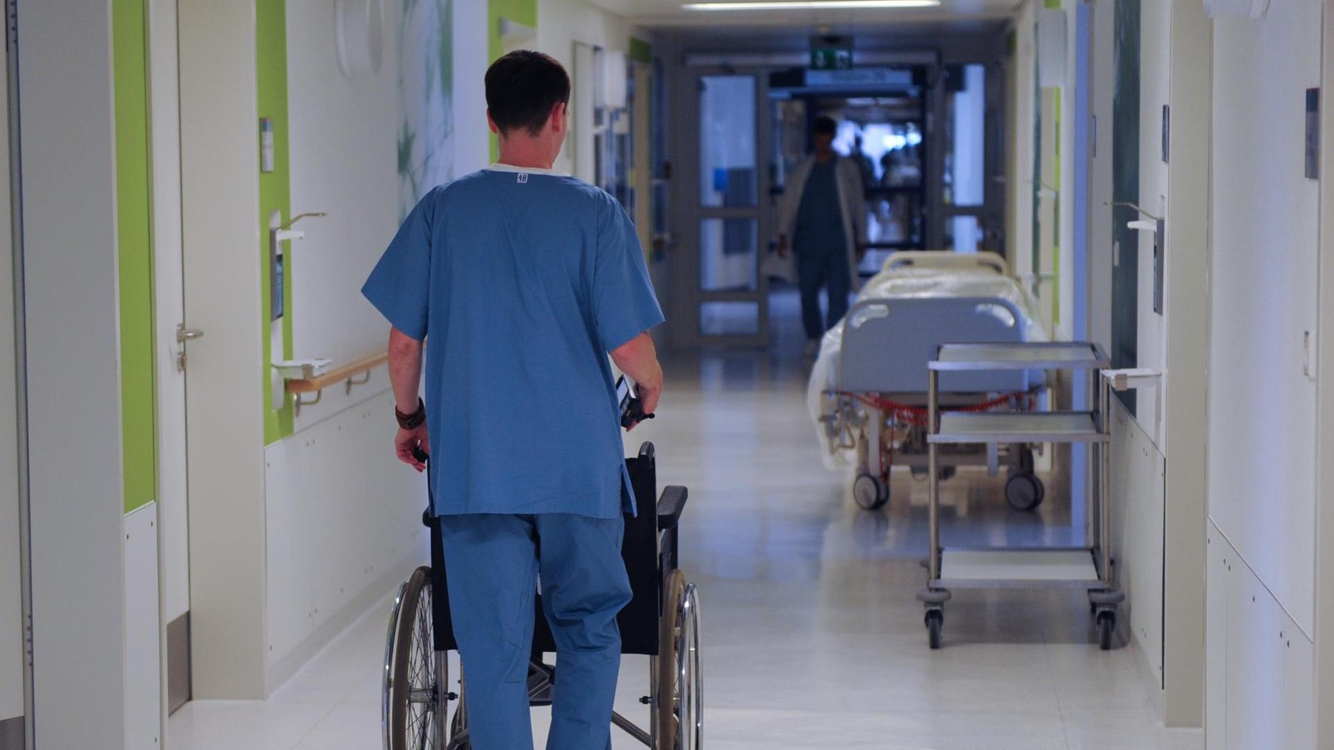 Ein Pfleger schiebt am Mittwoch (10.08.2011) mit einen Rollstuhl über einen Flur in der Medizinischen Hochschule in Hannover.