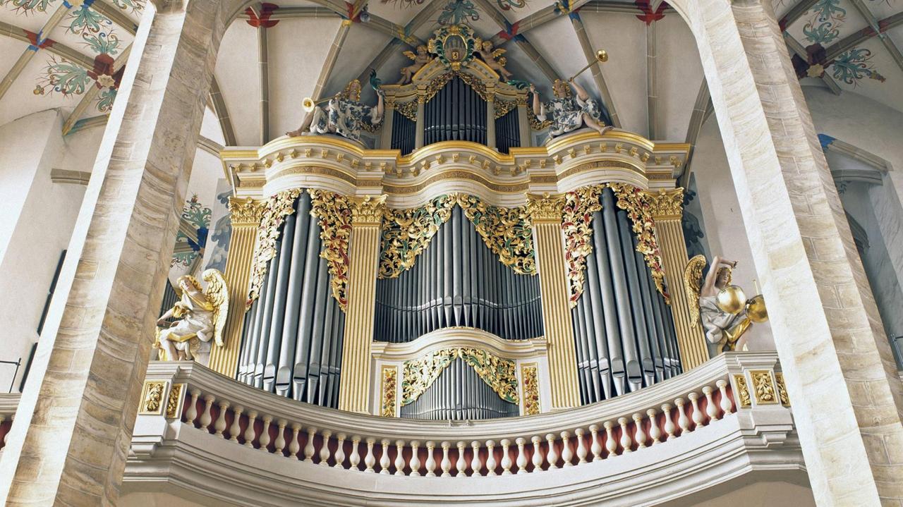 Blick von unten auf eine Orgelempore mit barock verziertem Instrument. Blick von unten auf eine Orgelempore mit barock verziertem Instrument.