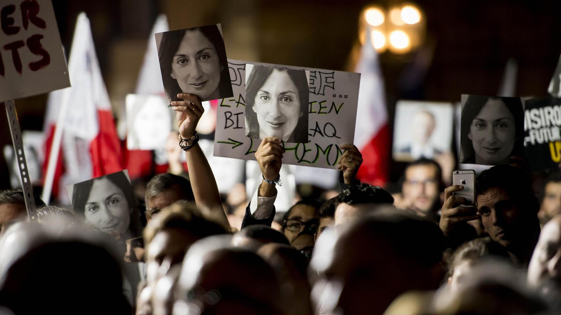 Foto der 2017 ermordeten Journalistin Daphne Caruana Galizia vor einer Wand, davor Kerzen Foto der 2017 ermordeten Journalistin Daphne Caruana Galizia vor einer Wand, davor Kerzen