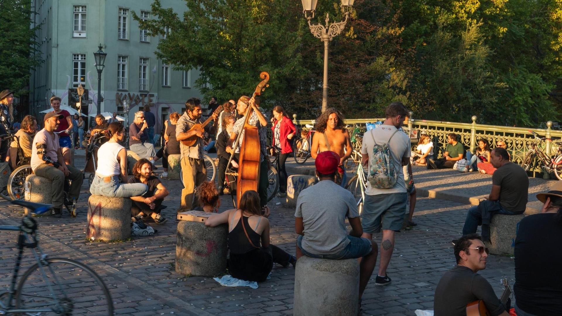 Auf der Admiralsbrücke sitzenzahlreiche Besucher, feiern und hören den Straßenmusiker bis spät in die Nacht zu. Auf der Admiralsbrücke sitzenzahlreiche Besucher, feiern und hören den Straßenmusiker bis spät in die Nacht zu.