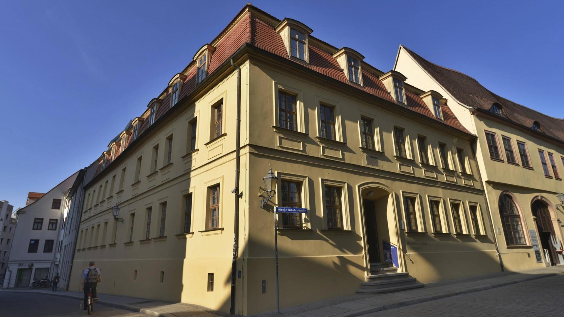 Das Händel-Haus in Halle, ein Steinhaus mit gelb-braunem Anstrich, bei blauem Himmel von außen fotografiert. Das Händel-Haus in Halle, ein Steinhaus mit gelb-braunem Anstrich, bei blauem Himmel von außen fotografiert.